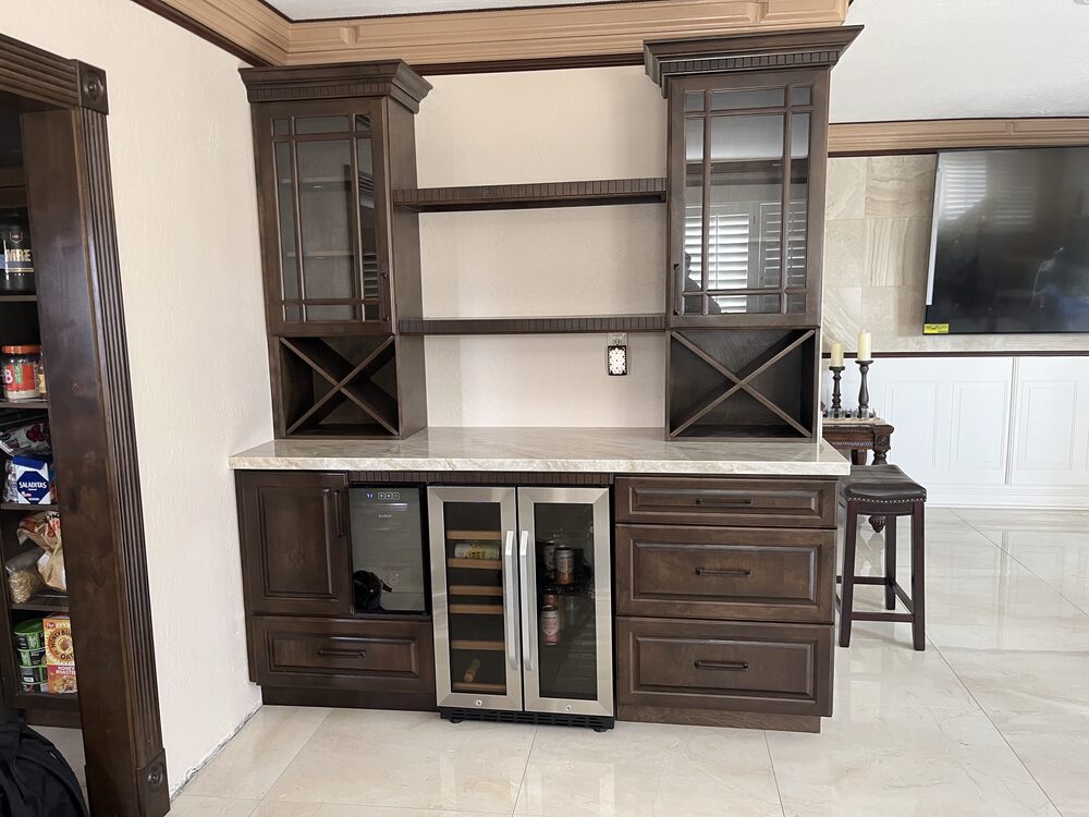 Walnut wet bar with wine refrigerator, X wine racks and a stone counter — Luxe Carpentry Group, San Diego