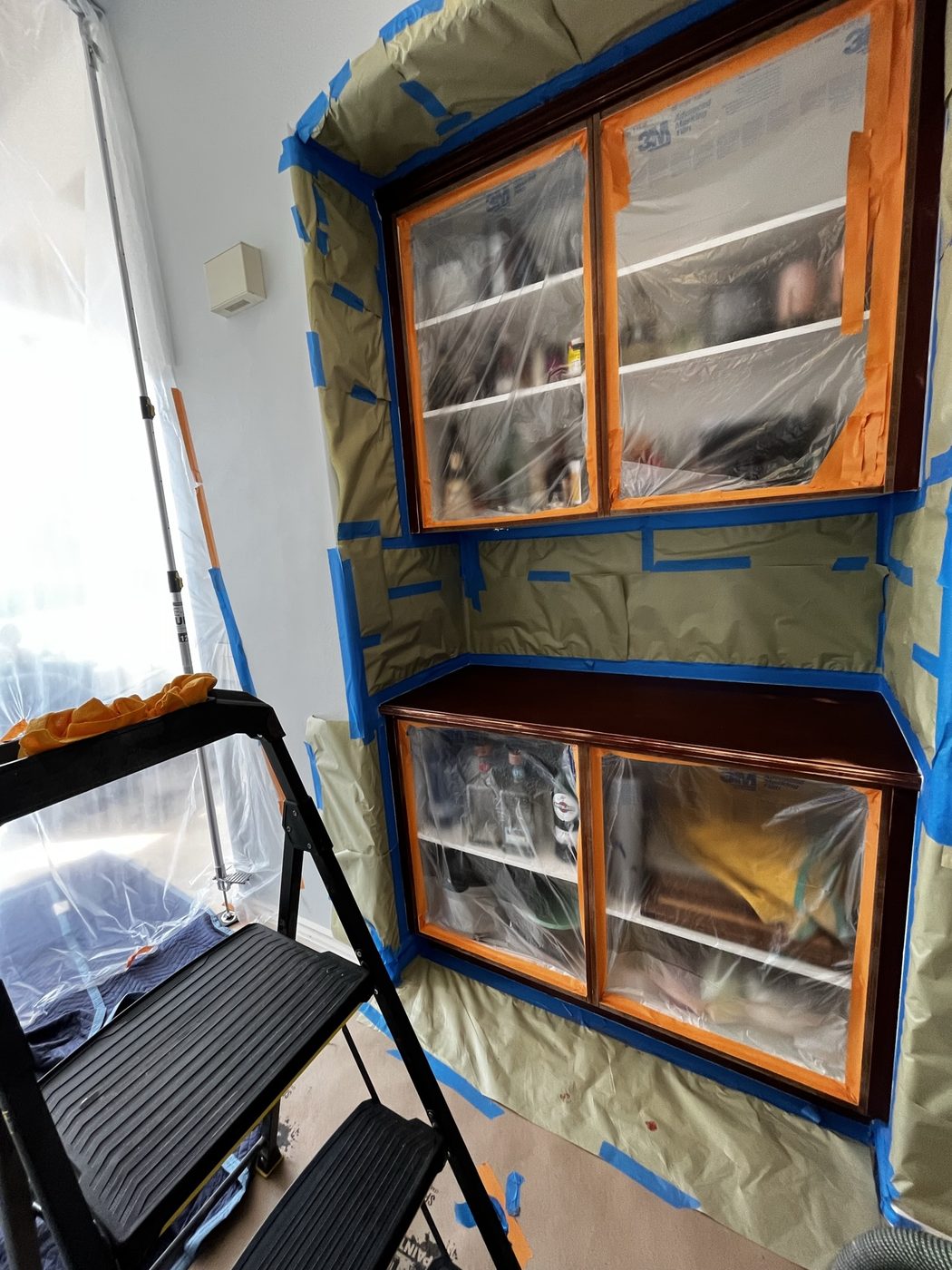 Cabinetry masked with paper and plastic for on-site refinishing — Luxe Carpentry Group, San Diego