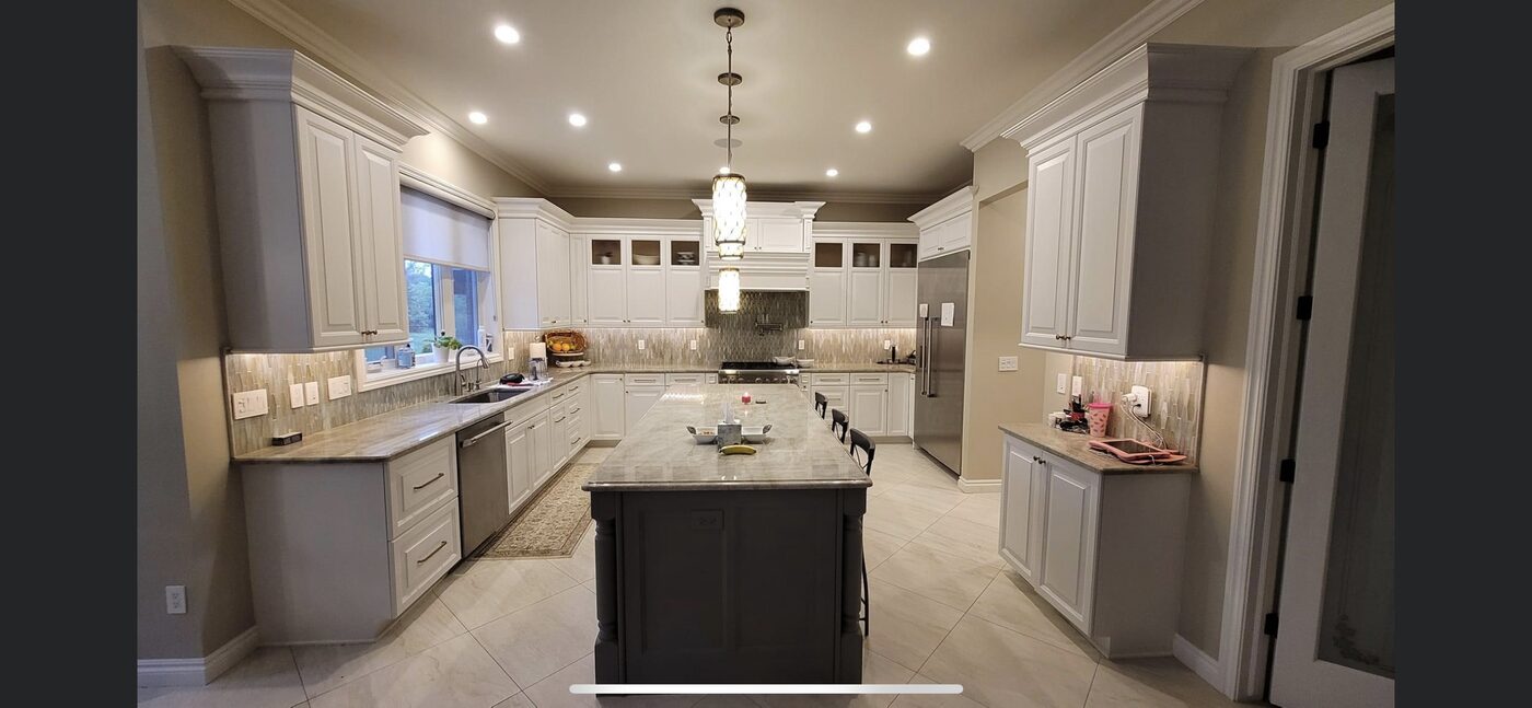 White custom kitchen with a dark island, pendant lighting and full-height cabinetry — Luxe Carpentry Group, San Diego