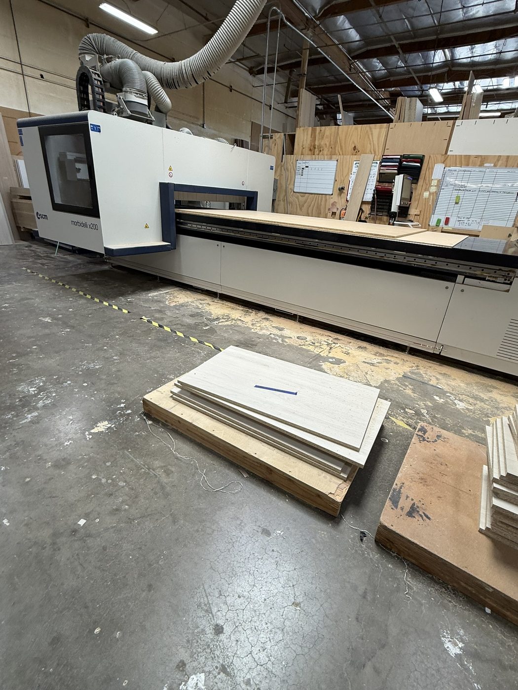 SCM Morbidelli X200 CNC with machined cabinet parts on the shop floor — Luxe Carpentry Group, San Diego