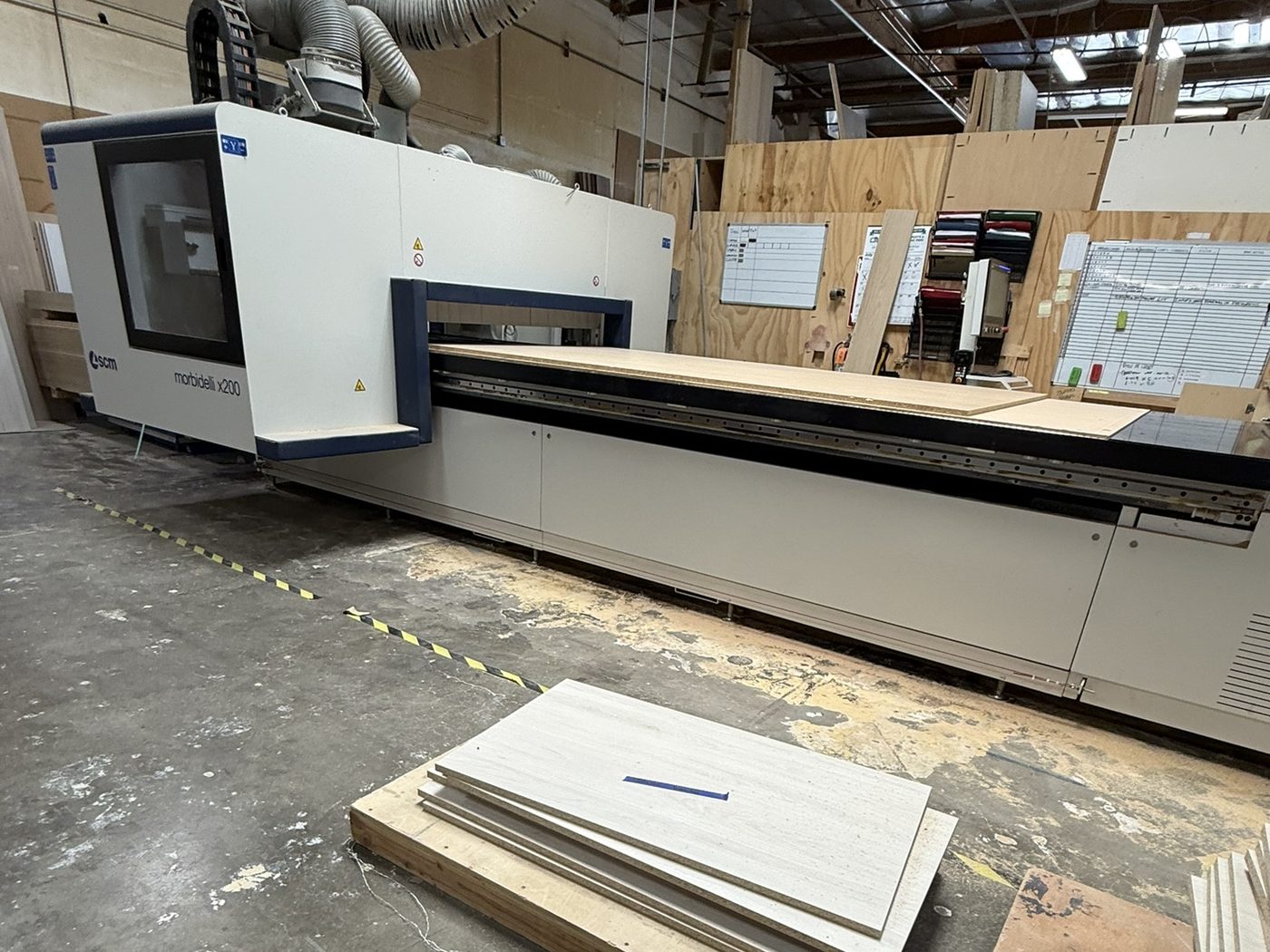 Cabinet shop floor with the SCM Morbidelli X200 CNC and freshly cut panels — Luxe Carpentry Group, San Diego